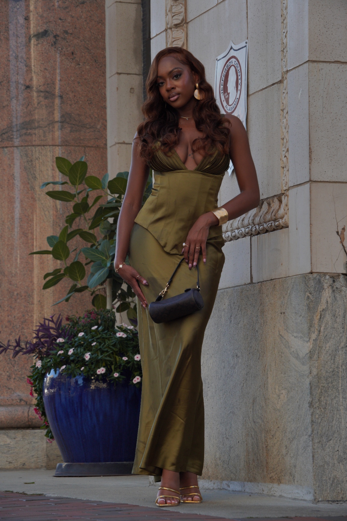 Woman in an olive gown posed outdoors for a CAMSNAPPED portrait.