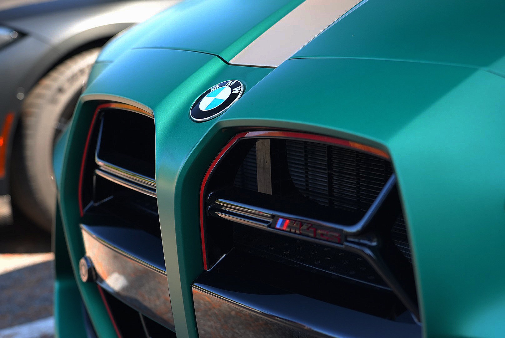 Close-up of a green BMW M4 CS grille and badge.