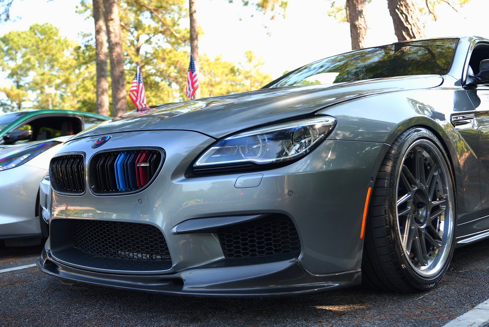Grey BMW M6 with carbon front lip photographed low at a car meet.