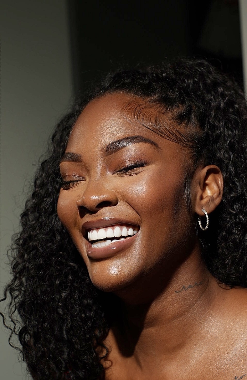 Close-up portrait with glowing skin and a radiant smile.