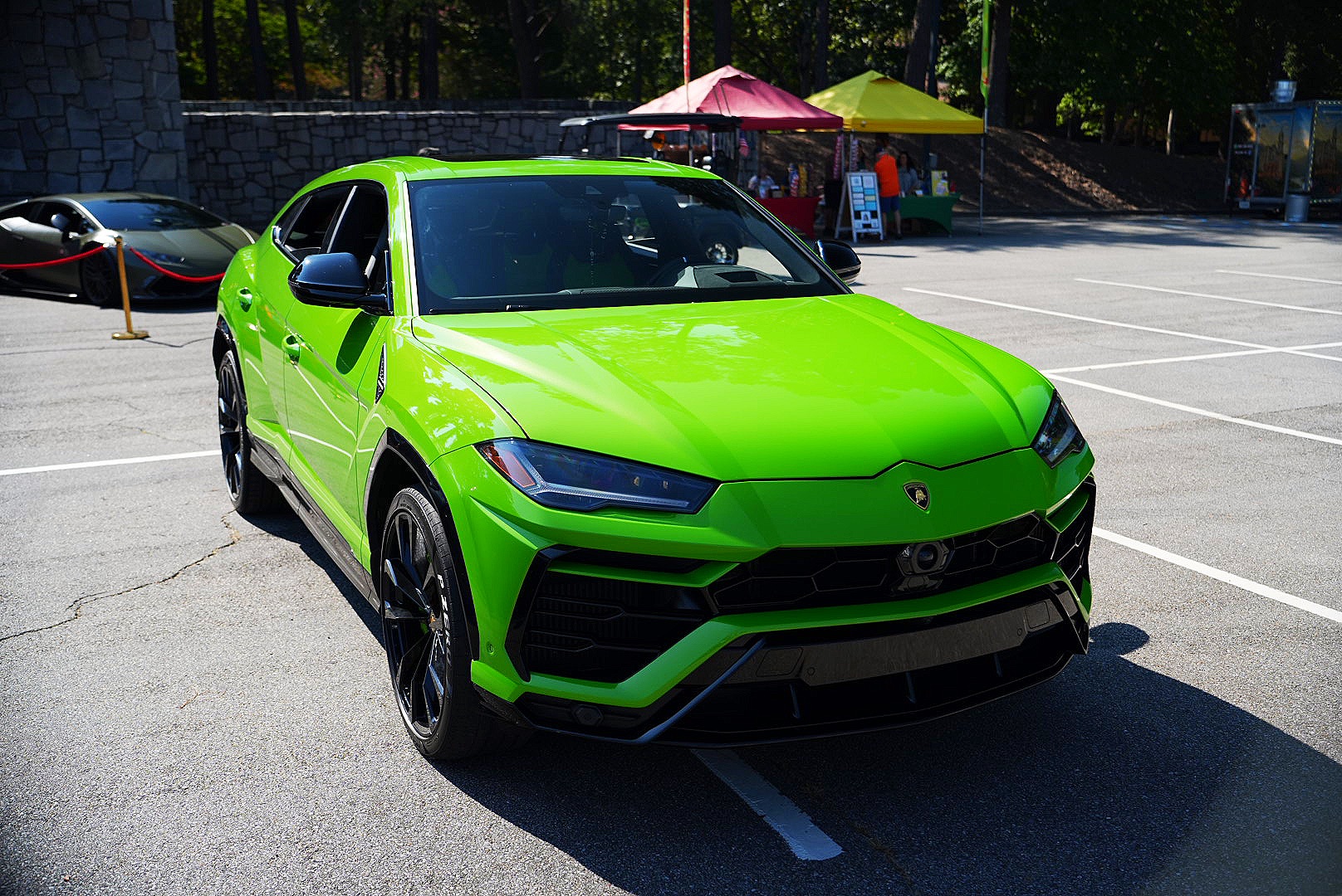 Green Lamborghini Urus photographed at a car show.