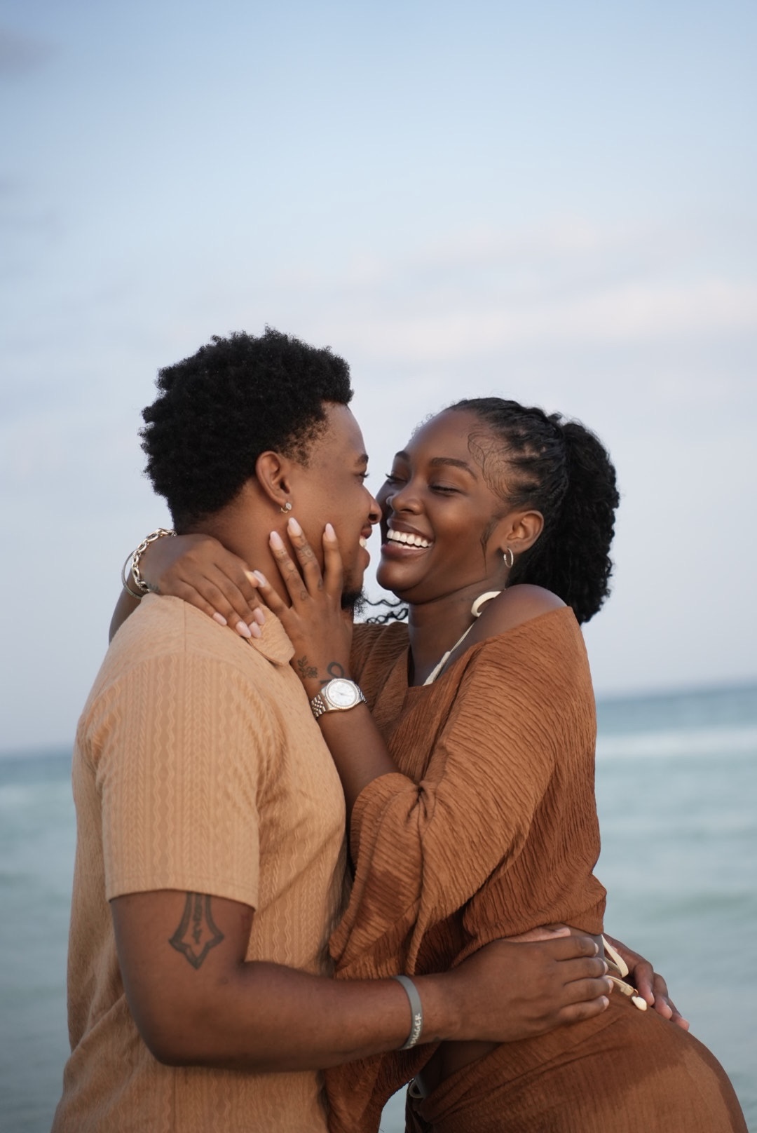 Couple laughing together during a beach engagement session.